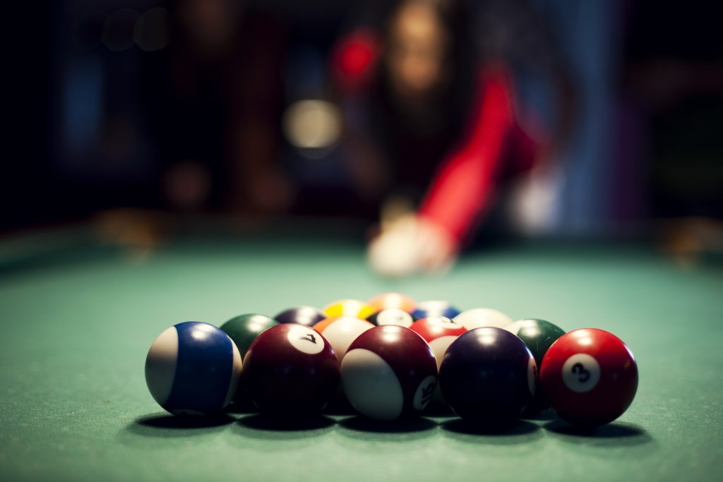 Young woman playing billiard